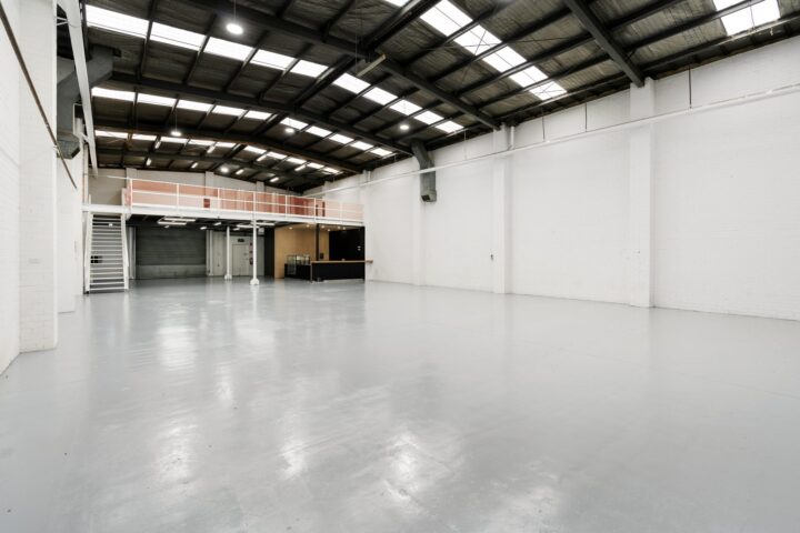 Large empty white warehouse with a mezzanine